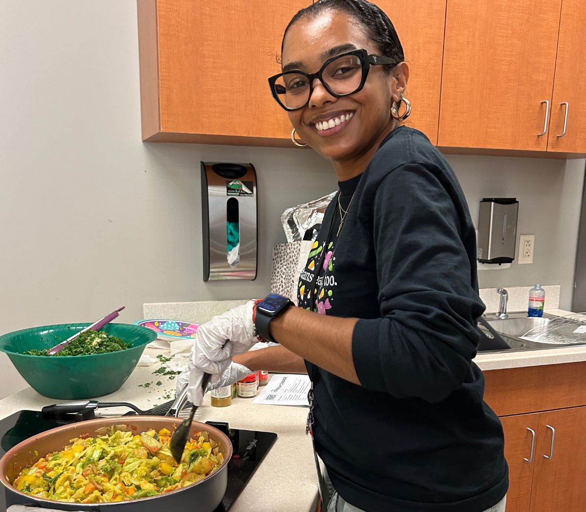 A cook stirs a fresh plant-based dish
