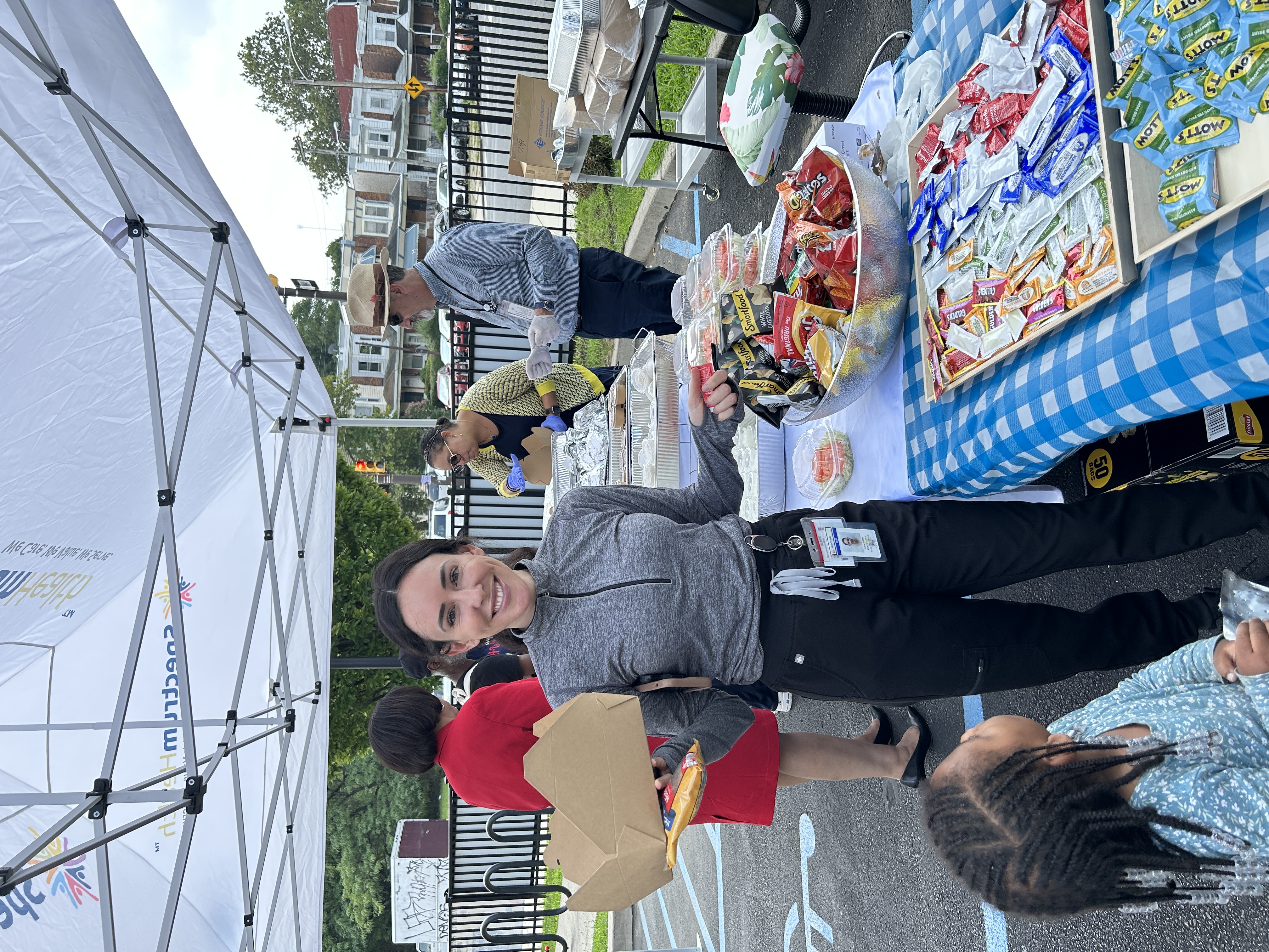 A staff member serves food at a barbecue table
