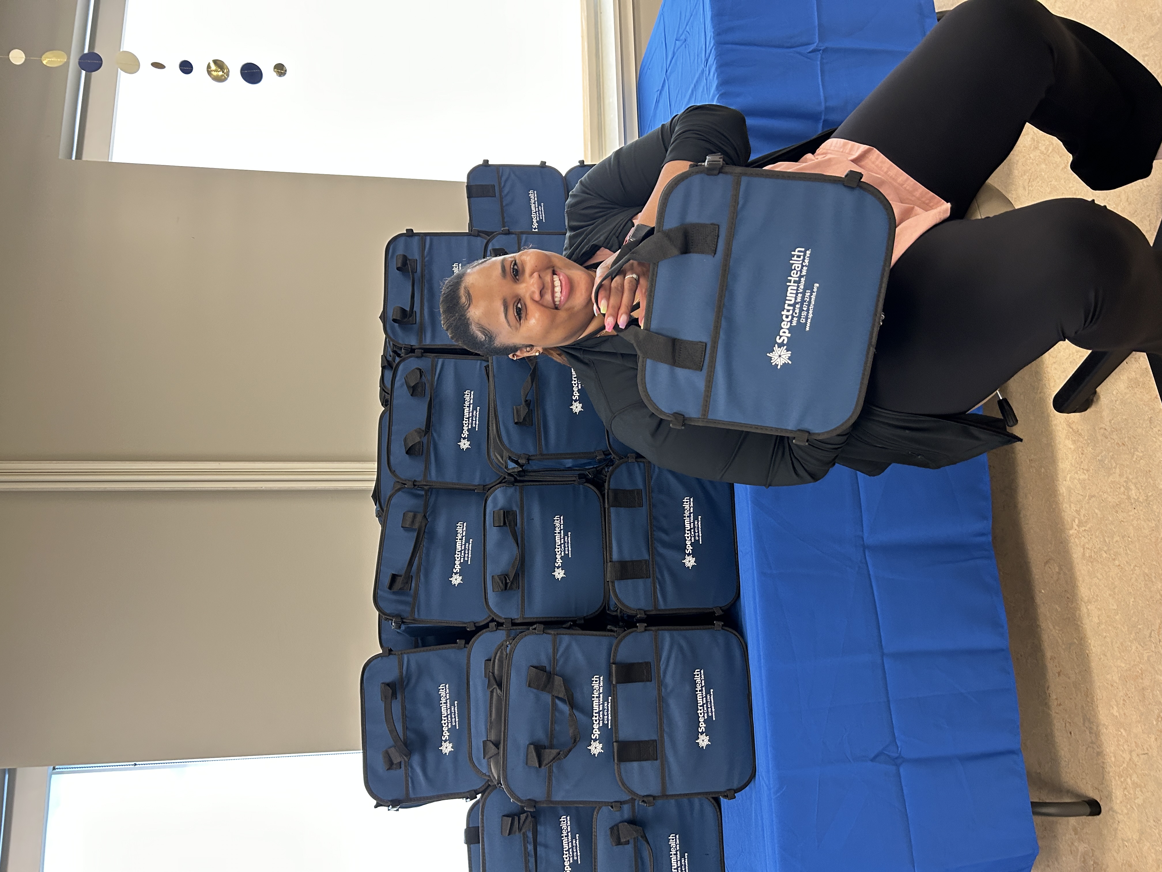 A staff member with giveaway bags at the barbecue