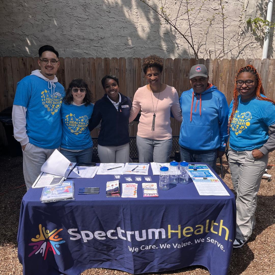 The Spectrum team in blue shirts behind their table in the park