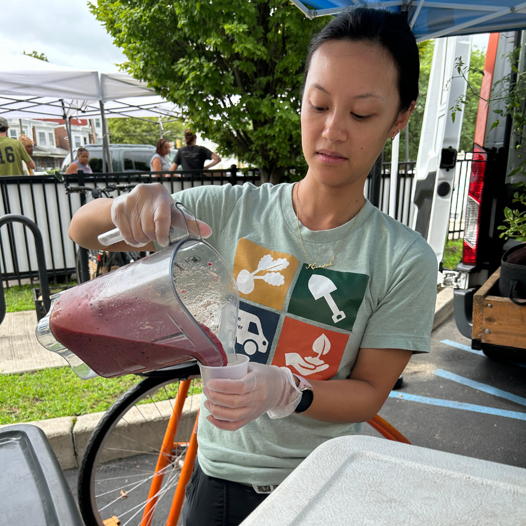 A woman pours a smoothie made on the smoothie bike