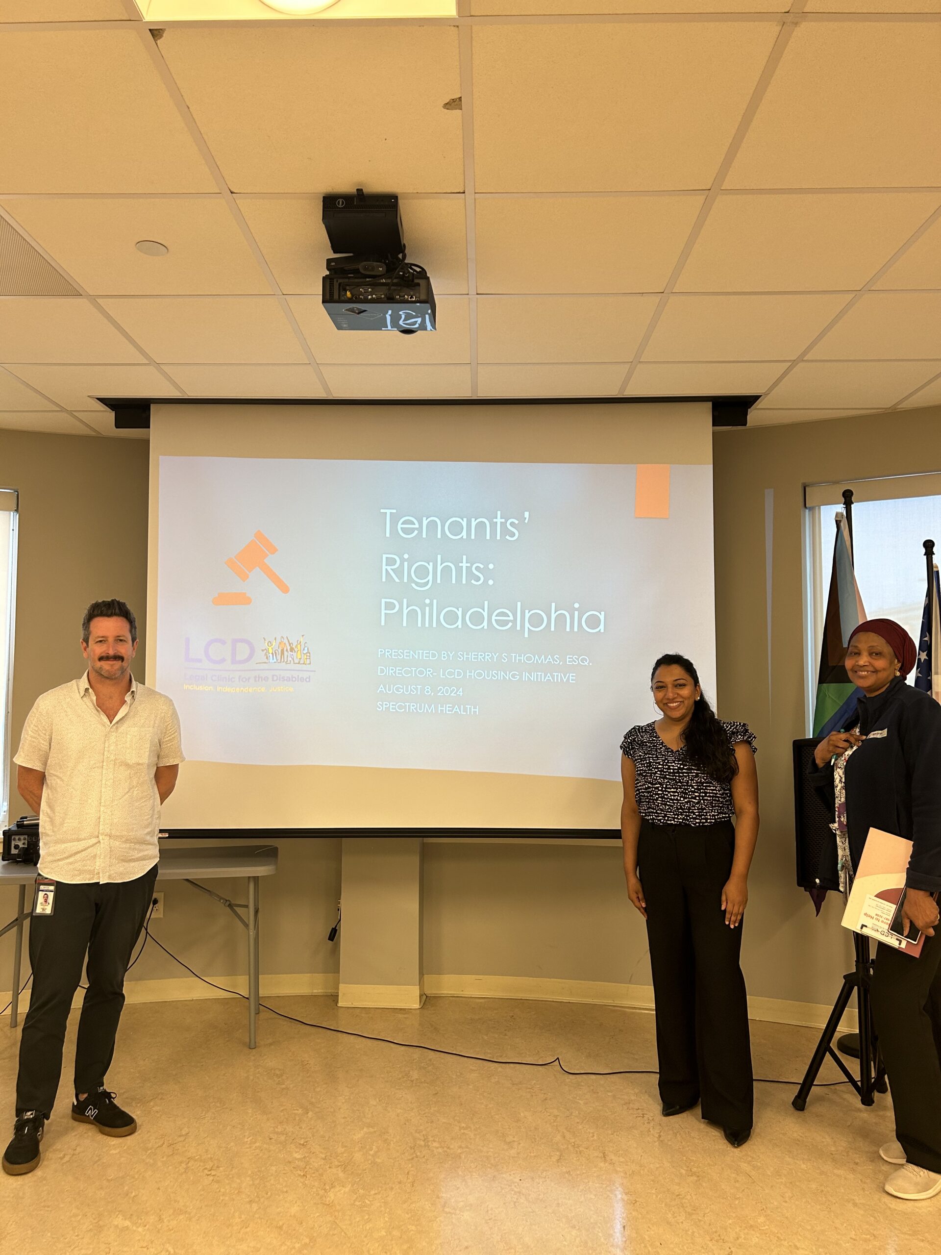 Presenters stand in front of a screen at the tenants’ rights workshop