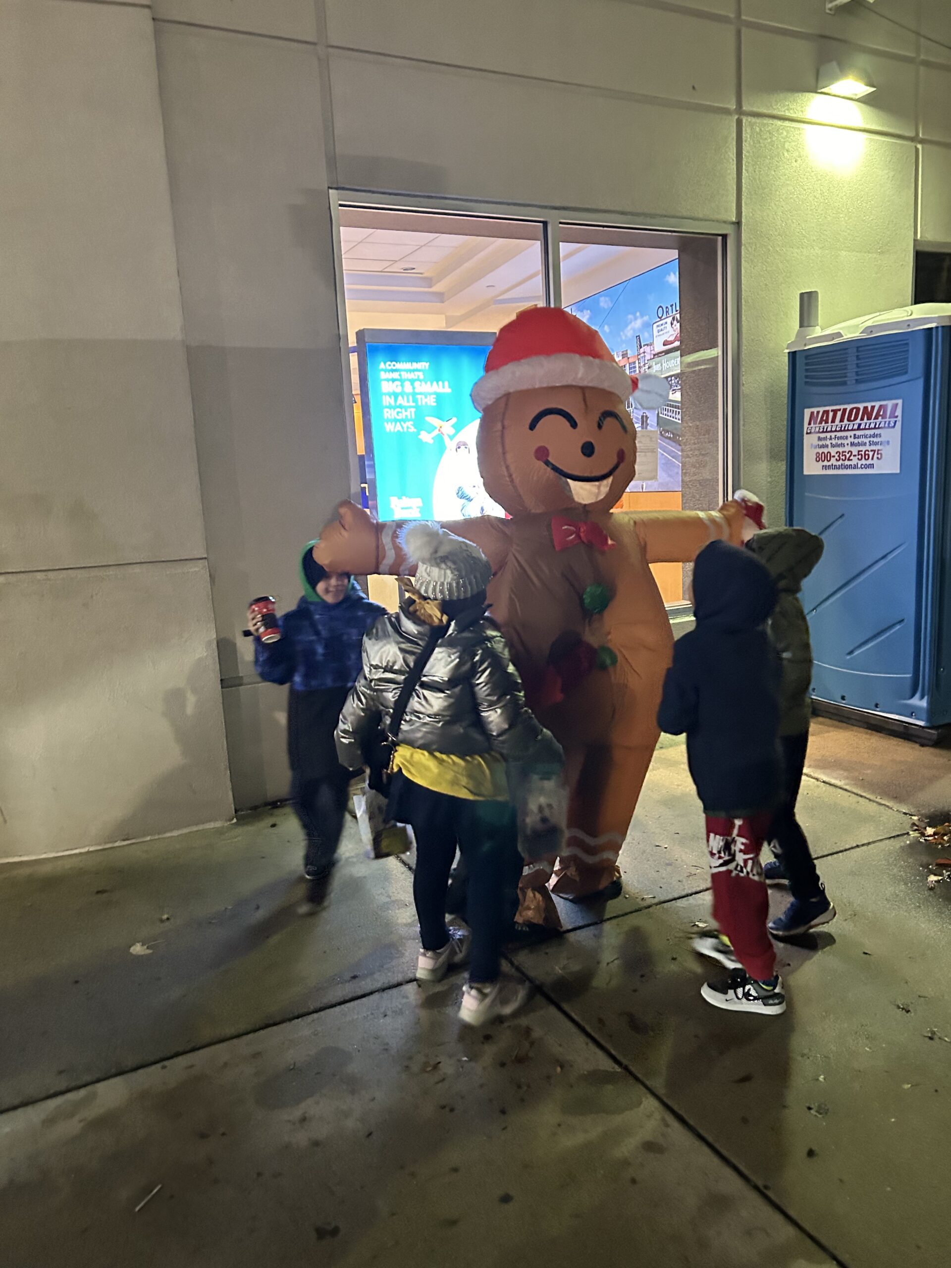 Families gather around the gingerbread man at night