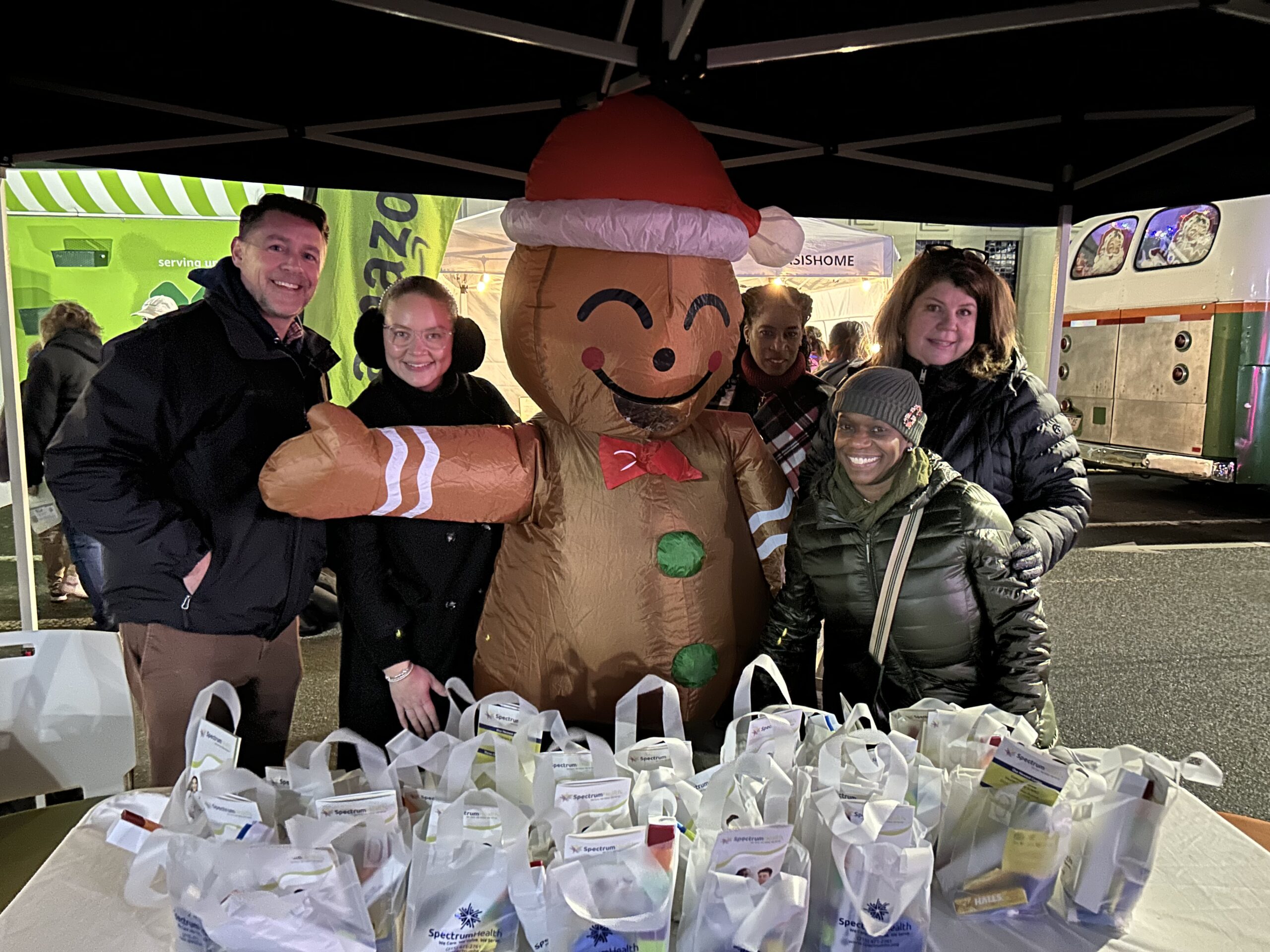 Spectrum staff hand out goodie bags next to the gingerbread man