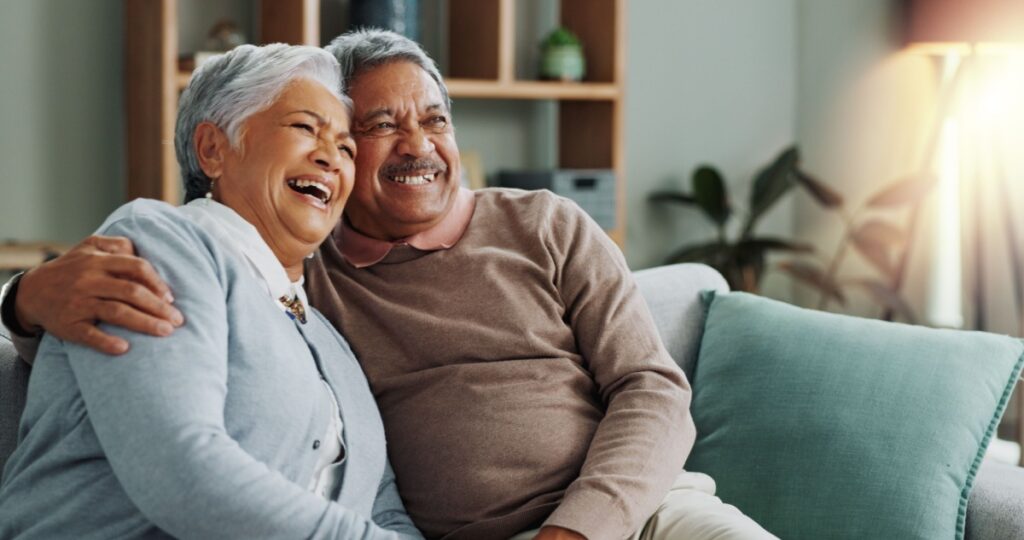 older couple laughing and cuddling on the couch