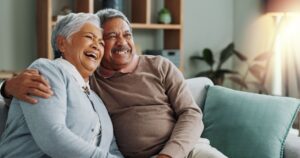 older couple laughing and cuddling on the couch