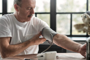 Older man taking his blood pressure at home
