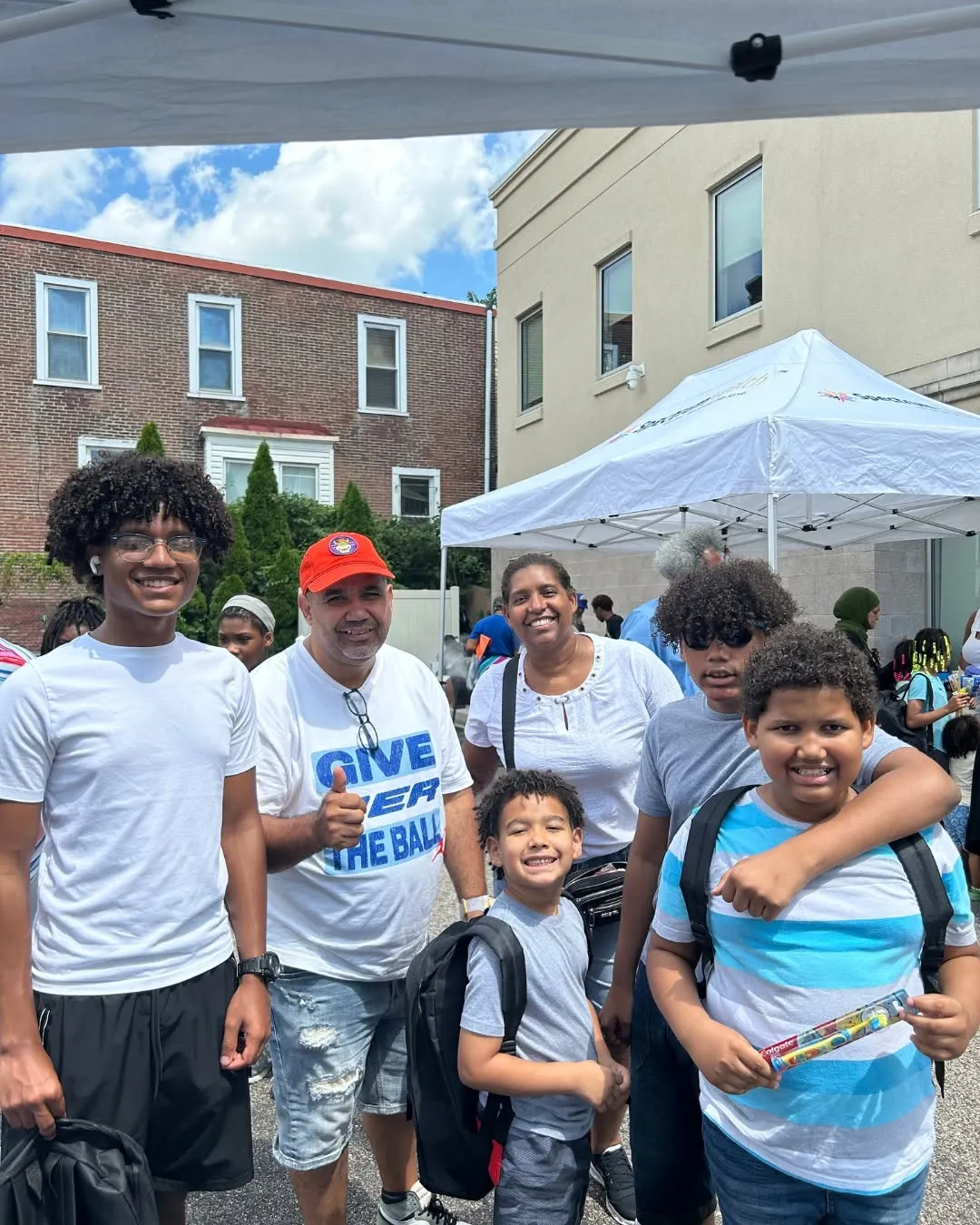 Kids and grown-ups smile together at the Children’s Health Day Fair.