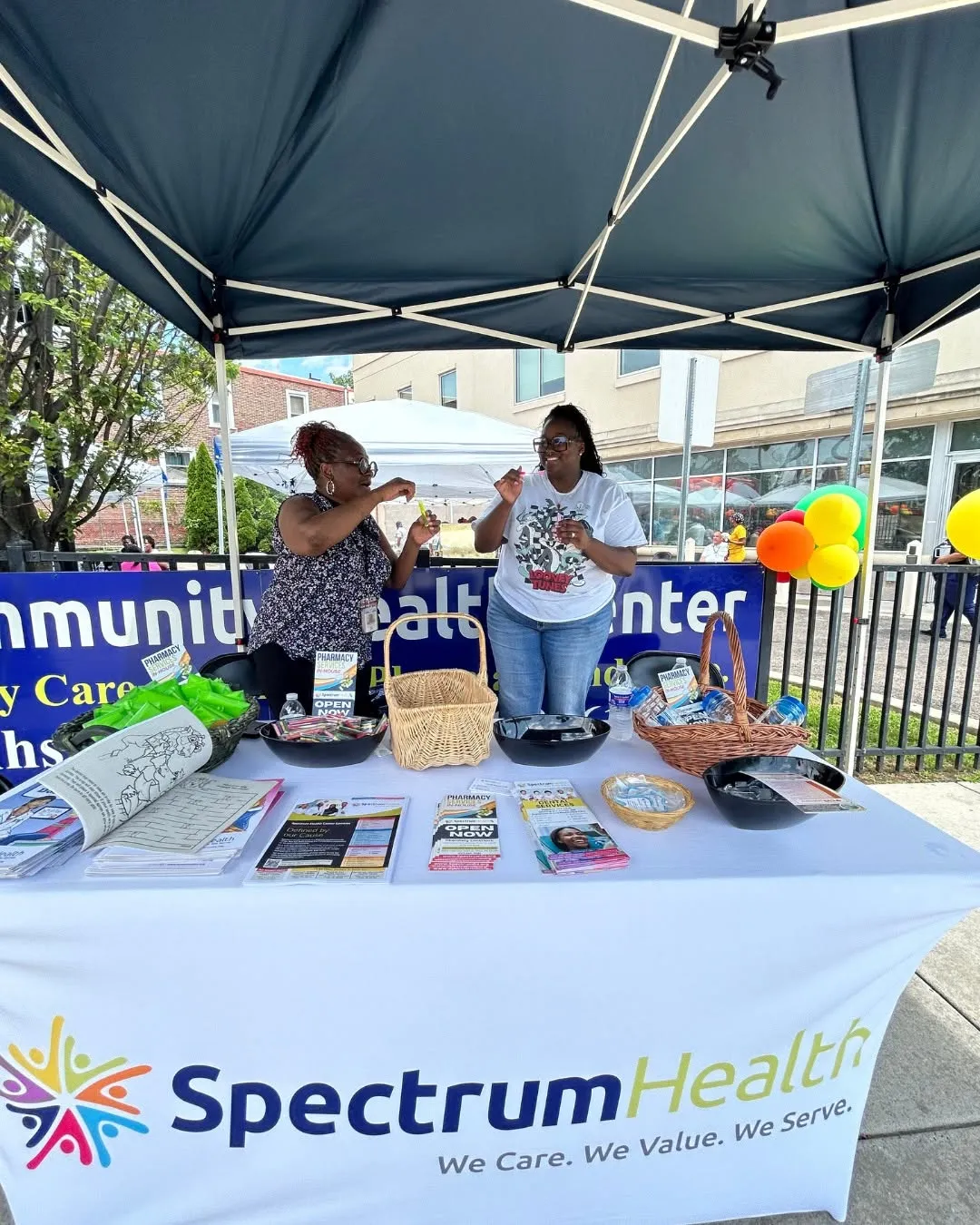 Staff members welcome families at the Spectrum Health tent.
