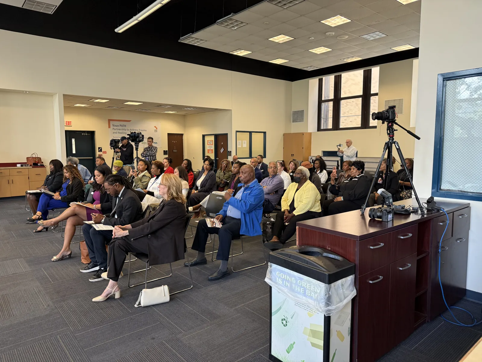 Guests sit in rows and listen during the grand opening program.